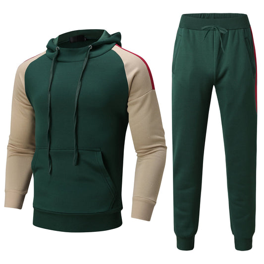 Tuta sportiva verde con felpa a cappuccio e pantaloni, maniche beige con strisce rosse. Abbigliamento casual uomo, moda autunno-inverno.