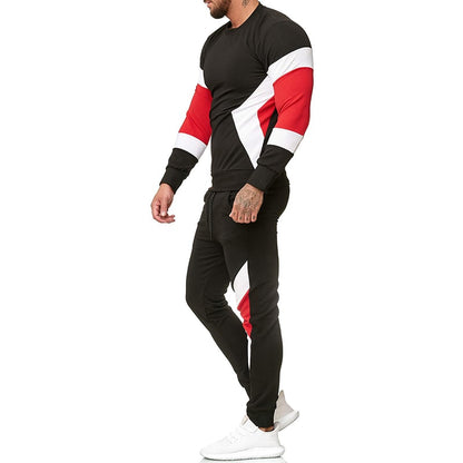Uomo in tuta sportiva nera con dettagli rossi e bianchi, scarpe da ginnastica bianche. Abbigliamento casual, moda uomo, stile sportivo.