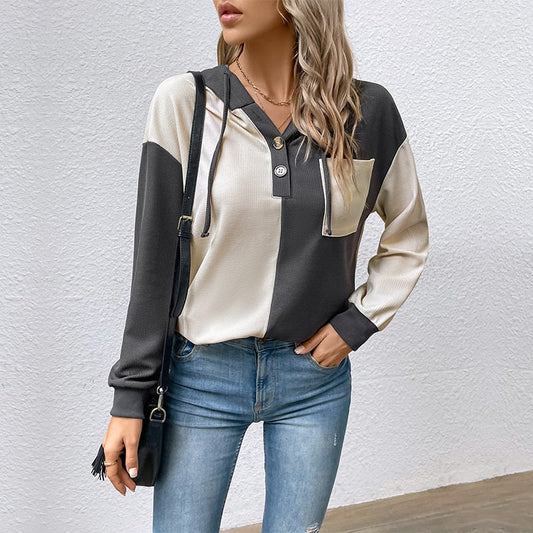 Donna con maglia bicolore bianco e nero, jeans aderenti, borsa a tracolla nera. Moda casual autunnale, stile urbano chic.