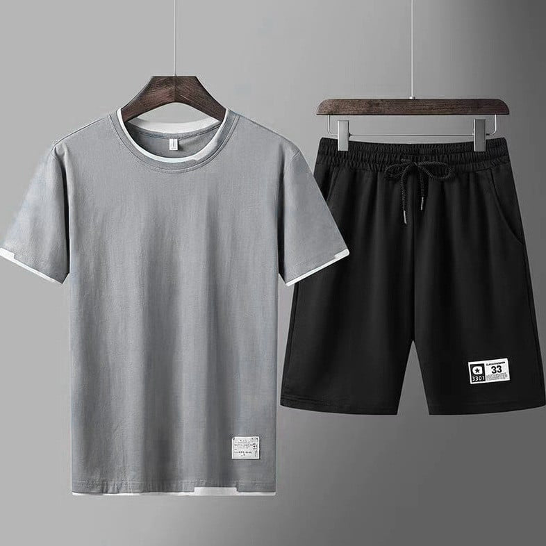 Completo sportivo uomo: maglietta grigia e pantaloncini neri. Abbigliamento casual estivo, moda uomo, tessuto traspirante, stile minimalista.