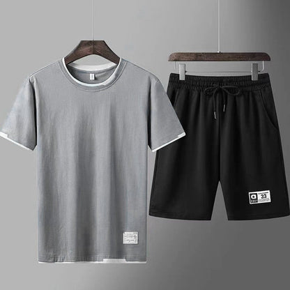 Completo sportivo uomo: maglietta grigia e pantaloncini neri. Abbigliamento casual estivo, moda uomo, tessuto traspirante, stile minimalista.