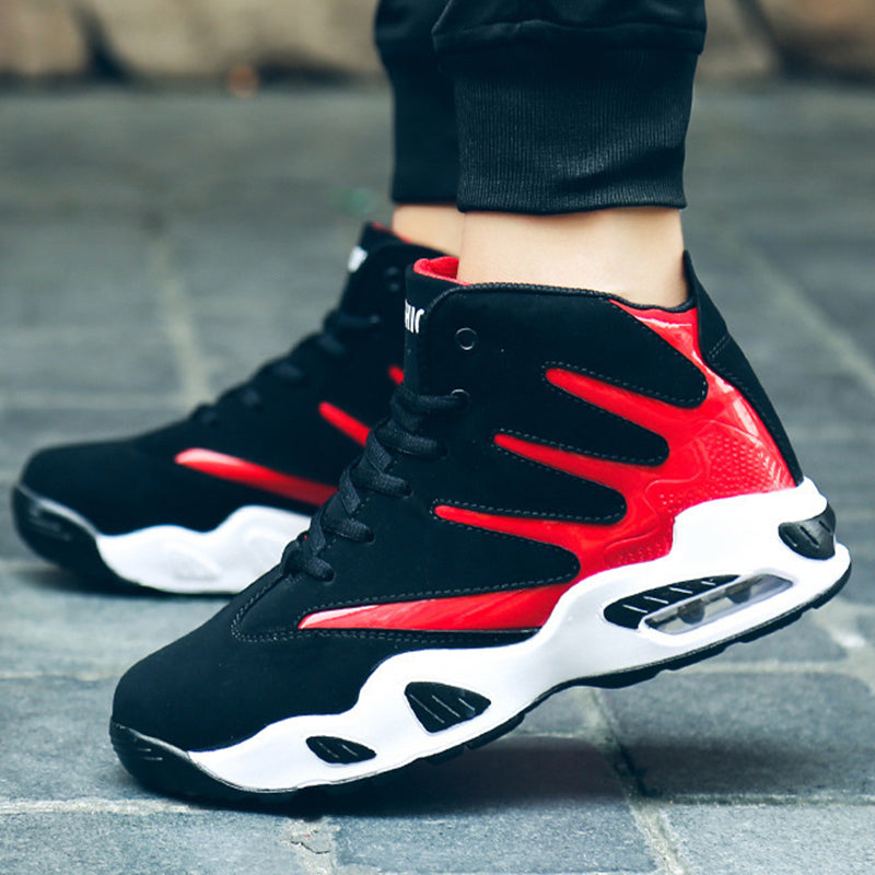 Scarpe da ginnastica nere e rosse su pavimento grigio, design moderno con suola ammortizzata. Scarpe sportive uomo, moda casual, comfort urbano.