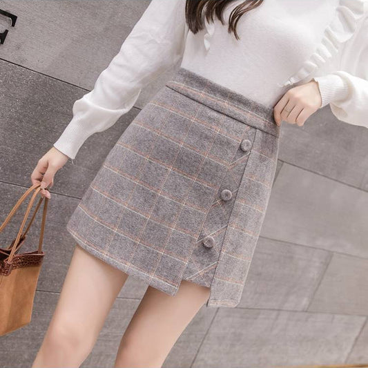 Donna con gonna a quadri grigia e maglione bianco, borsa marrone. Moda autunnale elegante, abbigliamento casual chic, tendenze femminili 2023.
