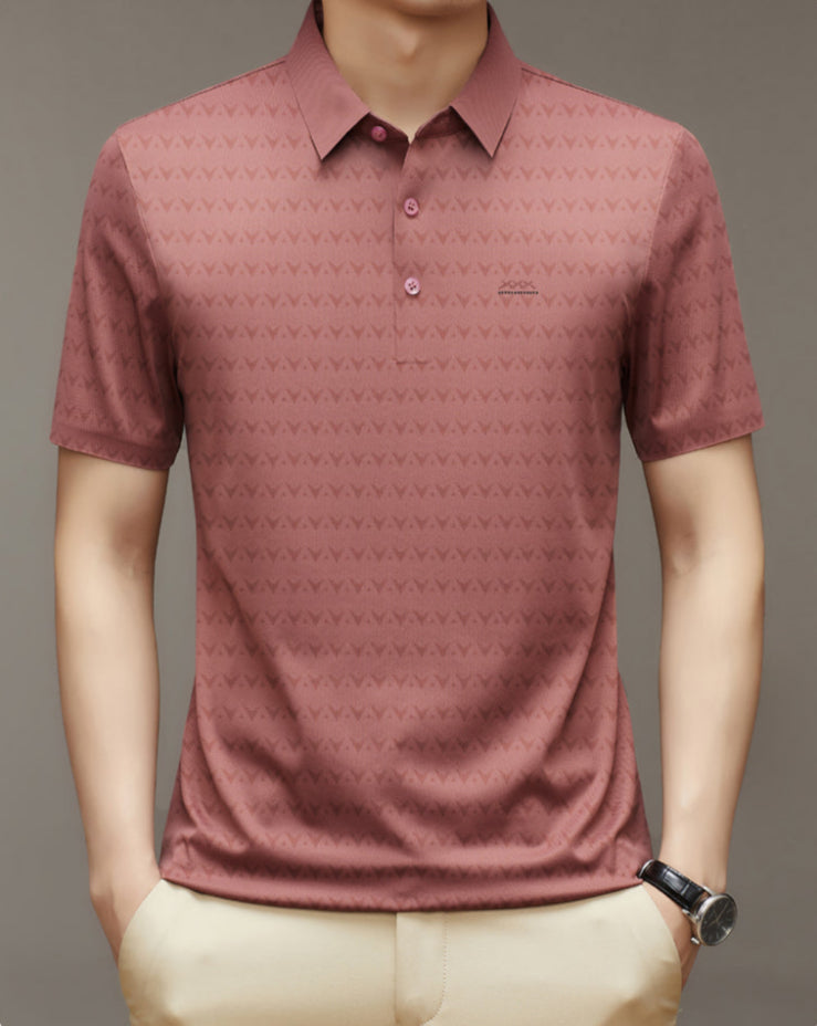 Camicia polo uomo rosa con motivo geometrico, maniche corte, colletto classico, abbinata a pantaloni beige. Stile casual elegante.