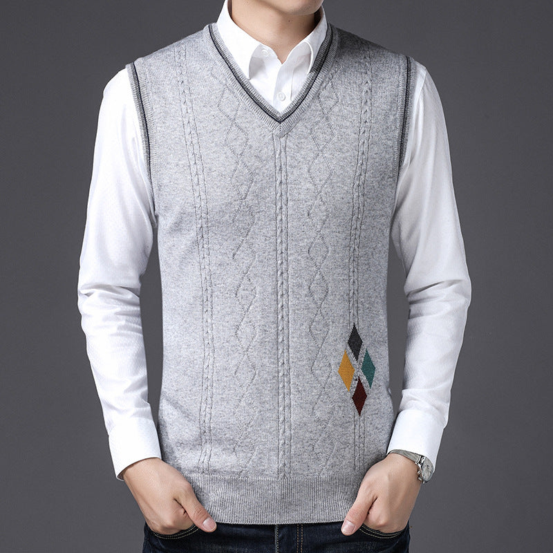 Gilet uomo grigio in maglia con motivo rombi, indossato su camicia bianca. Elegante abbigliamento maschile, moda autunnale, stile casual chic.