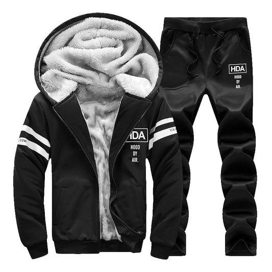 Tuta sportiva invernale nera con cappuccio, interno in pelliccia sintetica, dettagli bianchi, ideale per abbigliamento casual e sportivo.