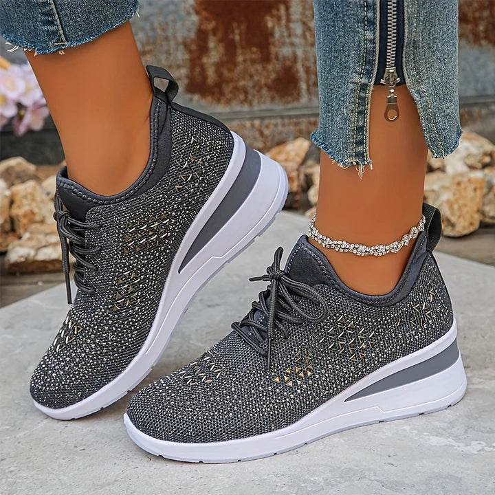 Scarpe da ginnastica nere con suola bianca, indossate con jeans strappati. Design traspirante, perfette per moda casual e comfort quotidiano.