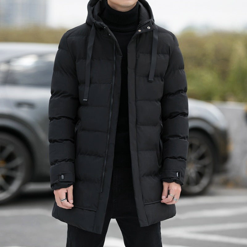 Giacca invernale uomo nera imbottita, con cappuccio e chiusura a zip, indossata all'aperto. Stile casual, ideale per il freddo.