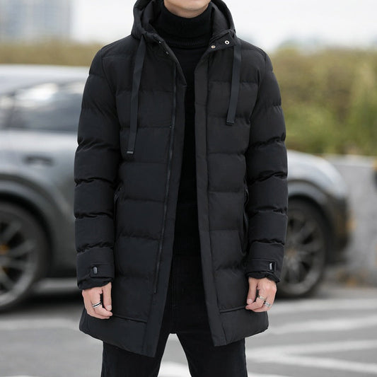 Giacca invernale uomo nera imbottita, con cappuccio e chiusura a zip, indossata all'aperto. Stile casual, ideale per il freddo.