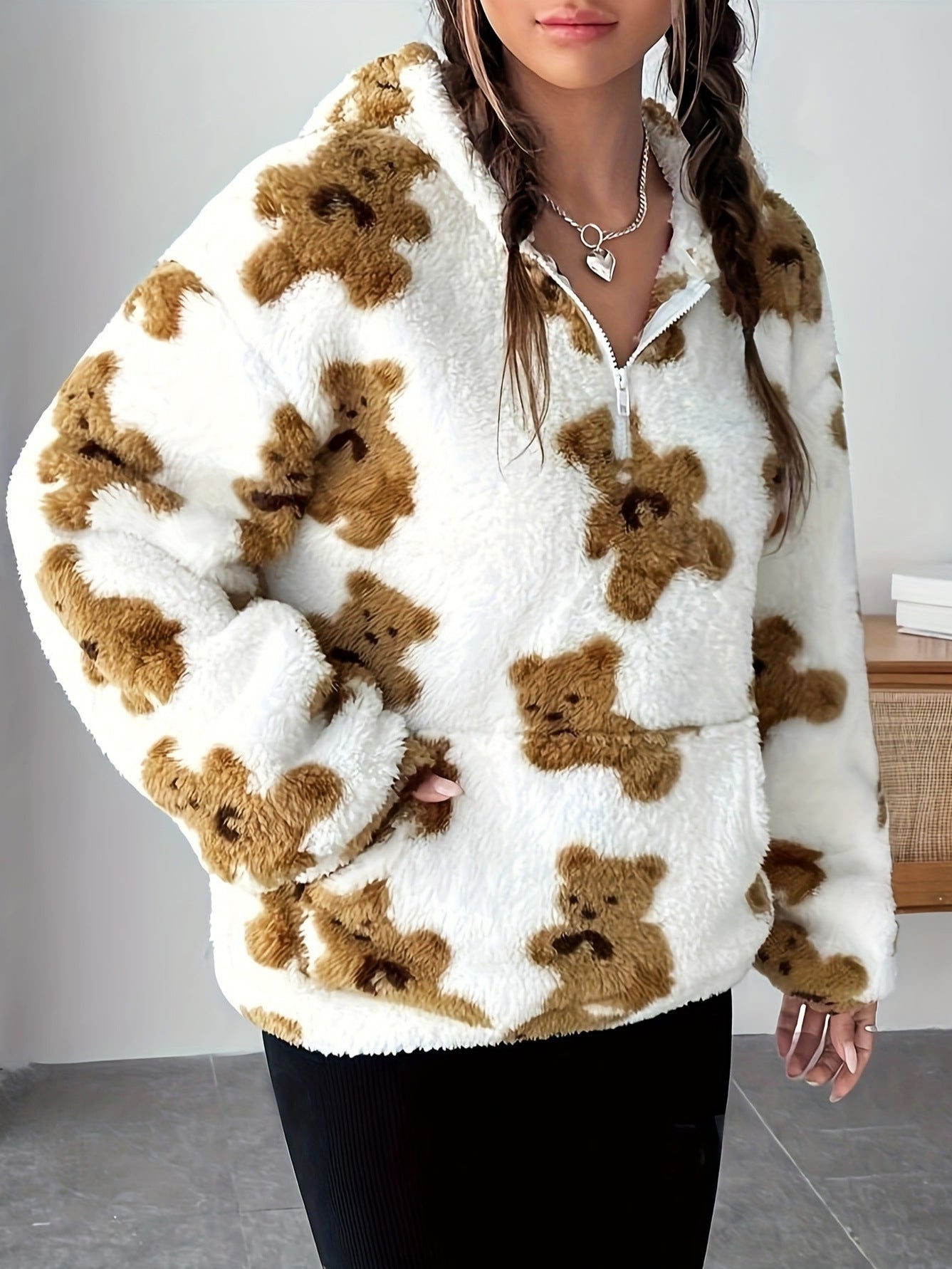 Giacca in pile bianco con motivo orsetti marroni, chiusura a zip, indossata da una donna. Moda autunnale, abbigliamento casual caldo e accogliente.