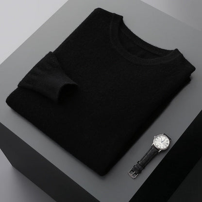 Maglione nero in cashmere piegato su tavolo grigio, accanto a orologio da polso elegante. Moda uomo, abbigliamento invernale, accessori di lusso.