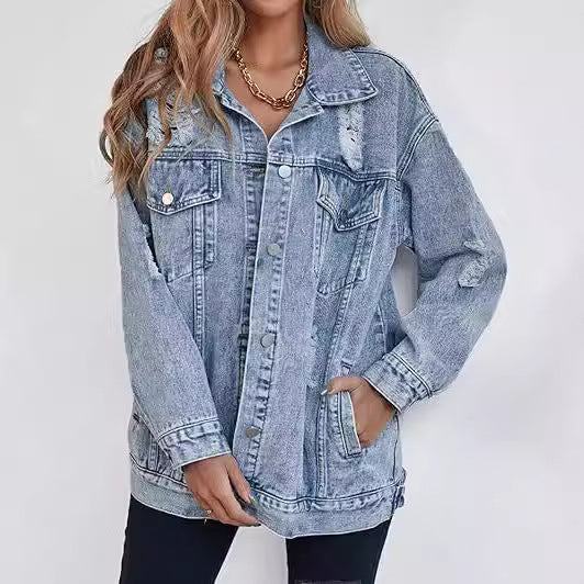 Giacca di jeans oversize da donna, stile casual, con dettagli strappati, abbinata a pantaloni neri. Moda denim, tendenza autunno.