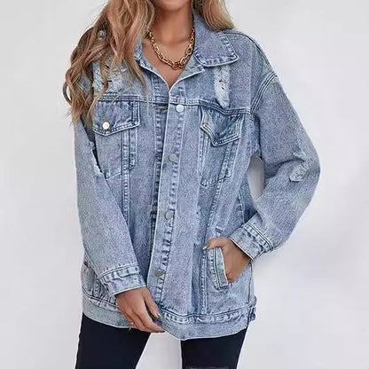 Giacca di jeans oversize da donna, stile casual, con dettagli strappati, abbinata a pantaloni neri. Moda denim, tendenza autunno.