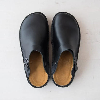 Scarpe sabot nere in pelle, design minimalista, suola interna marrone chiaro, chiusura laterale, viste dall'alto su sfondo bianco.