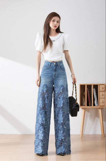 Giovane donna in jeans a zampa con ricami floreali e maglia bianca, posa in interni moderni. Moda femminile, abbigliamento casual elegante.