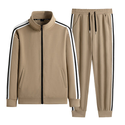 Tuta sportiva beige con giacca e pantaloni, dettagli a righe bianche e nere, zip frontale, tasche laterali, stile casual e moderno.
