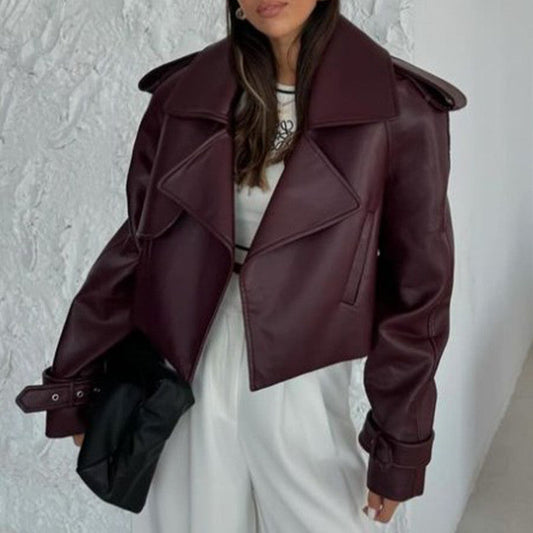 Giacca in pelle bordeaux da donna, stile oversize, abbinata a pantaloni bianchi. Moda autunnale elegante, tendenza abbigliamento femminile.