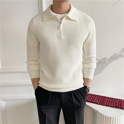 Uomo con maglione bianco a coste e pantaloni neri, in posa elegante. Moda maschile autunnale, stile casual chic, abbigliamento moderno.