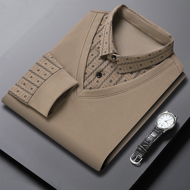Camicia elegante beige piegata con colletto e polsini a fantasia, accanto a un orologio da polso in pelle nera su sfondo grigio. Moda uomo formale.