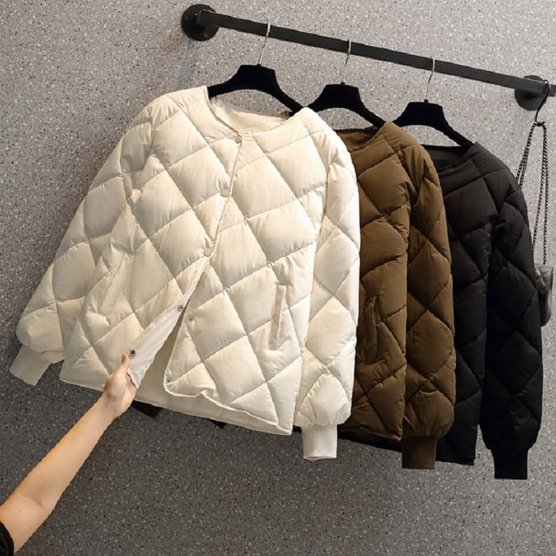 Giacche trapuntate appese: bianca, marrone e nera. Moda invernale, abbigliamento caldo, design elegante. Giacche donna su appendiabiti.