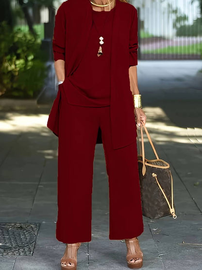 Donna in completo rosso elegante, con pantaloni larghi e giacca, indossa sandali con zeppa e borsa a mano marrone. Moda femminile urbana.
