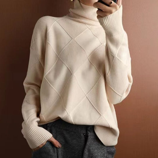 Maglione a collo alto beige con motivo a rombi, indossato con pantaloni grigi. Stile casual elegante, moda autunnale, abbigliamento caldo e confortevole.