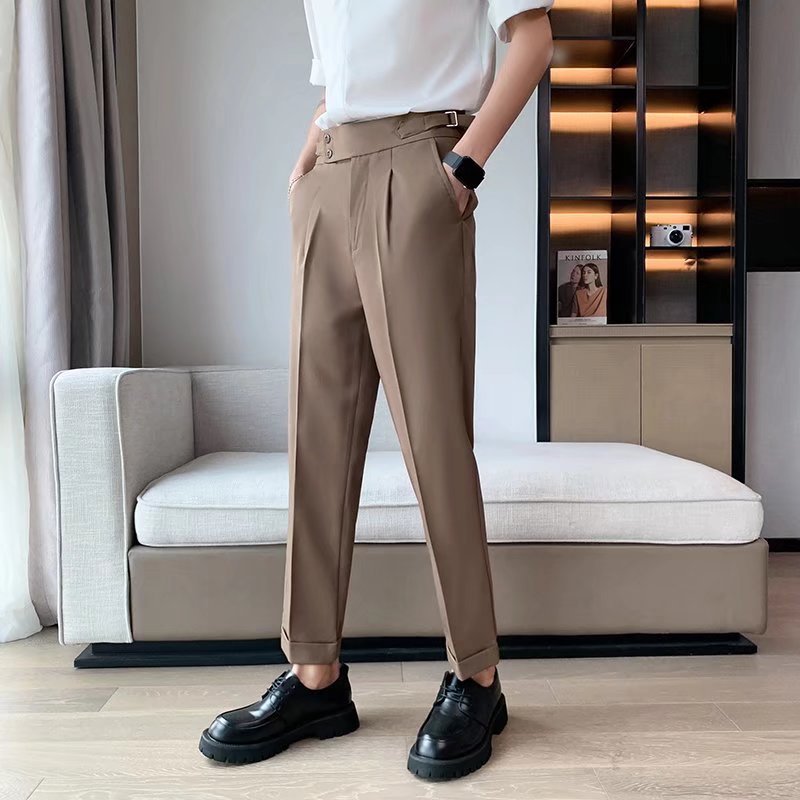 Pantaloni eleganti marroni da uomo con cintura, abbinati a scarpe nere lucide. Look moderno e sofisticato per moda maschile.