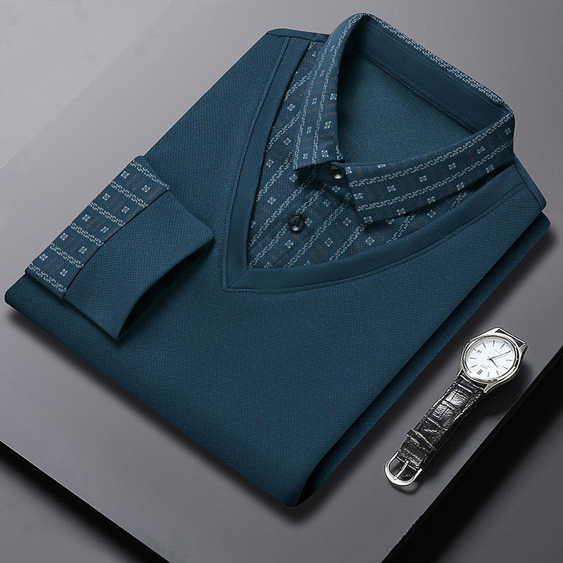 Camicia elegante blu scuro piegata su tavolo grigio, con orologio da polso in pelle nera. Stile formale, moda uomo, abbigliamento di lusso.
