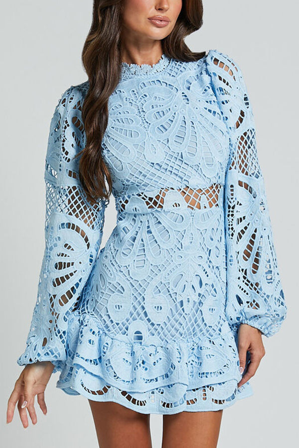 Abito corto in pizzo azzurro con maniche lunghe e dettagli floreali, ideale per moda femminile elegante e occasioni speciali.