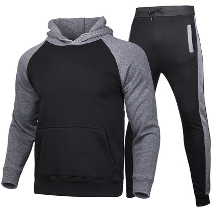 Tuta sportiva uomo invernale, felpa con cappuccio e pantaloni, colore nero e grigio, tessuto caldo, ideale per palestra e tempo libero.
