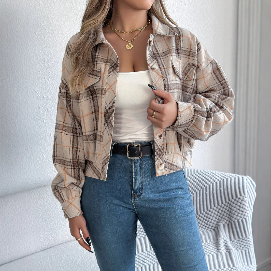 Donna con camicia a quadri beige e marrone, top bianco, jeans blu, collana dorata. Moda casual autunnale, abbigliamento femminile trendy.