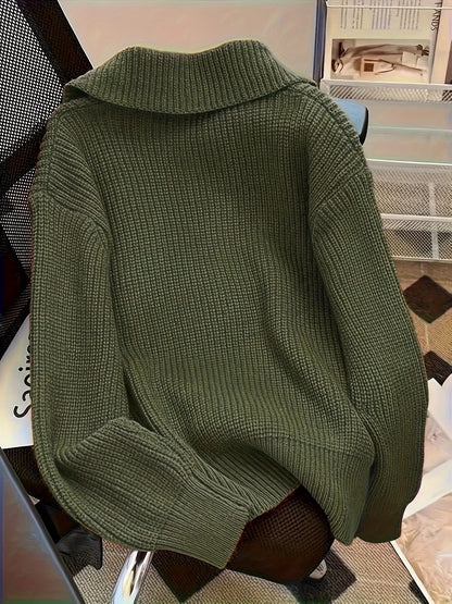Maglione verde oliva a maglia grossa su sedia, design casual e accogliente, perfetto per moda autunnale e invernale, stile caldo e confortevole.