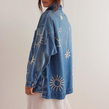Giacca di jeans oversize con ricami di sole e stelle, moda casual donna, stile boho chic, abbigliamento trendy, sfondo bianco.