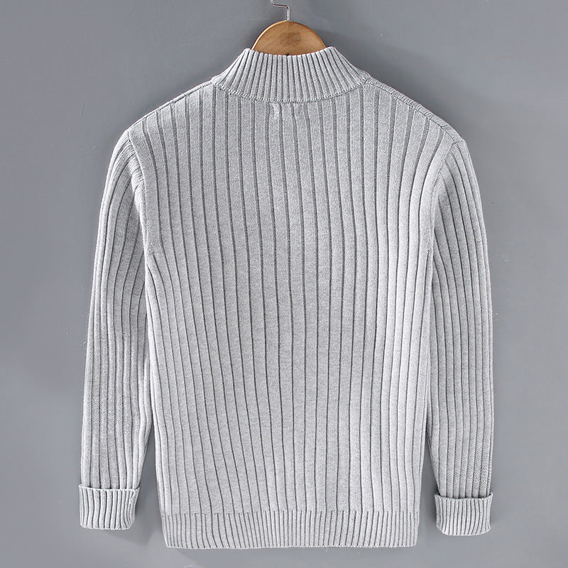 Maglione grigio a coste, maniche lunghe, su gruccia di legno. Design elegante e moderno, ideale per moda autunno-inverno.