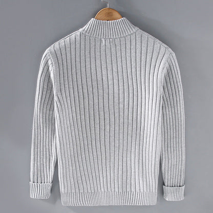 Maglione grigio a coste, maniche lunghe, su gruccia di legno. Design elegante e moderno, ideale per moda autunno-inverno.