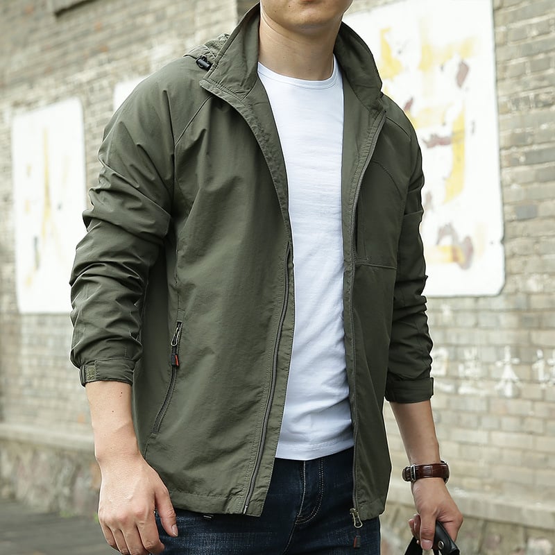 Giacca verde militare uomo, stile casual, con zip, indossata su maglietta bianca e jeans. Moda maschile urbana, look autunnale.