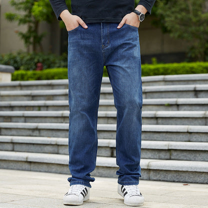 Uomo in jeans blu e scarpe da ginnastica bianche su gradini all'aperto. Moda casual maschile, abbigliamento urbano, stile quotidiano.
