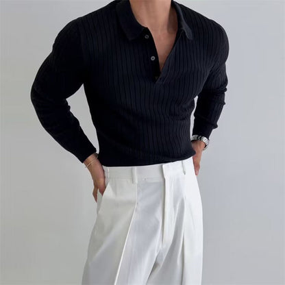 Uomo in maglione nero a coste e pantaloni bianchi eleganti, posa con mani sui fianchi. Moda maschile, abbigliamento casual chic.