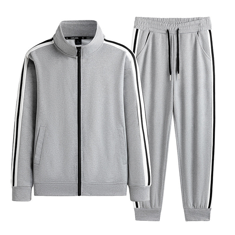 Tuta sportiva grigia da uomo con giacca a zip e pantaloni, dettagli a righe nere e bianche, ideale per allenamento e tempo libero.