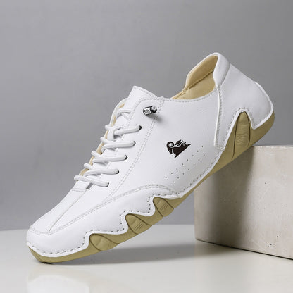 Scarpa da ginnastica bianca in pelle con suola beige, design moderno e logo laterale. Calzatura casual per uomo, stile sportivo ed elegante.