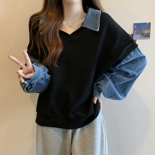 Donna con maglione nero e maniche in denim, posa con segno di pace. Moda casual, abbigliamento autunnale, stile urbano.