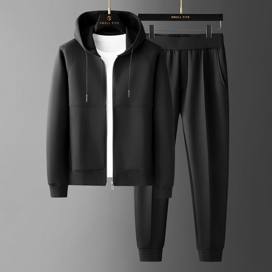 Tuta sportiva nera con felpa con cappuccio e pantaloni, appesa su grucce. Abbigliamento casual uomo, moda streetwear, stile moderno.