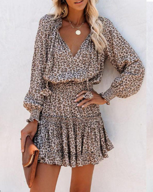Donna con abito leopardato a maniche lunghe, gonna a balze, accessori oro e borsa marrone. Moda femminile, stile casual chic, tendenze 2023.