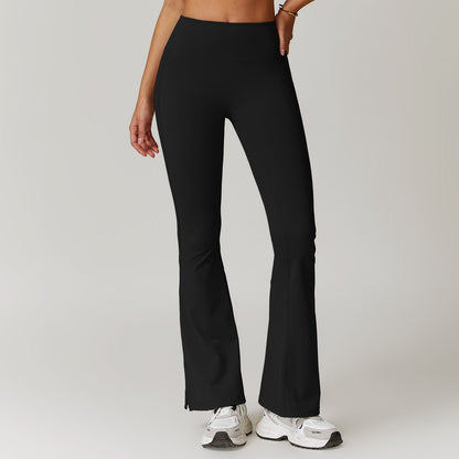 Pantaloni yoga neri a zampa, vita alta, indossati da una donna. Perfetti per fitness e moda casual. Scarpe da ginnastica bianche abbinate.