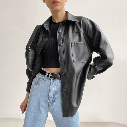 Giacca in pelle nera da donna, abbinata a jeans chiari e maglia nera. Moda casual autunnale, stile urbano, tendenze abbigliamento 2023.