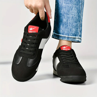 Scarpe da ginnastica nere con dettagli rossi e bianchi, indossate con jeans. Design moderno, casual e sportivo. Scarpe comode per uso quotidiano.