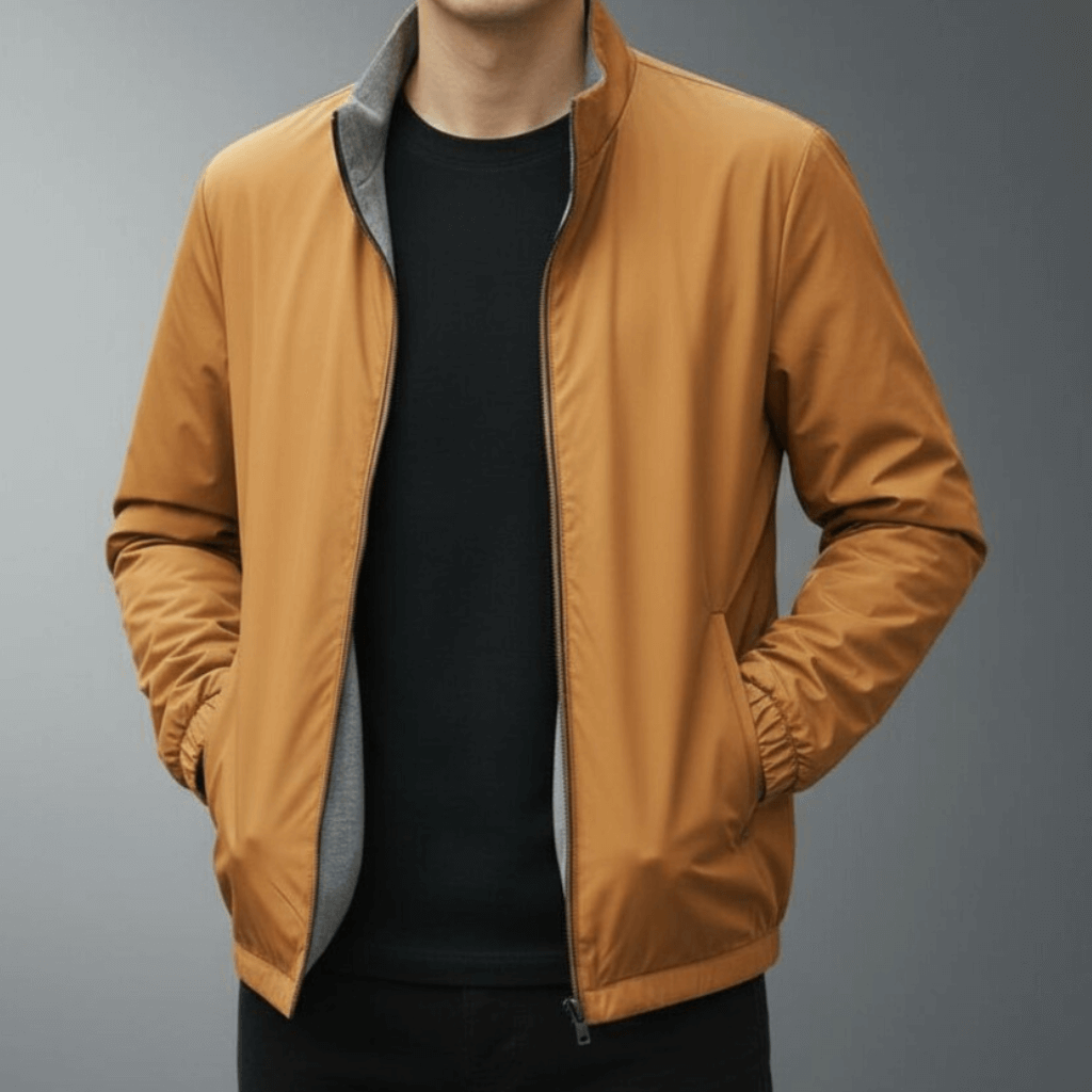 Giacca uomo marrone chiaro, stile casual, con zip frontale e tasche laterali, indossata su maglia nera. Moda maschile autunnale elegante.