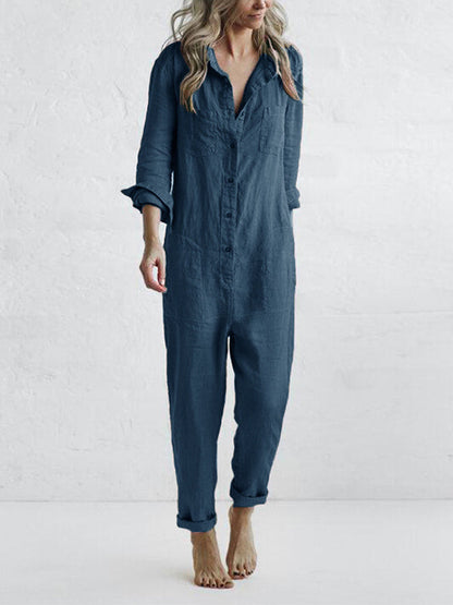 Donna in tuta jumpsuit blu scuro, maniche lunghe, tessuto leggero, stile casual, sfondo bianco. Moda femminile, abbigliamento comodo.