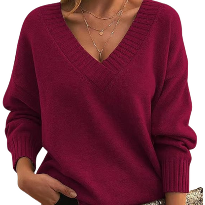 Maglione donna rosso bordeaux, scollo a V, maniche lunghe, abbinato a collane dorate. Moda autunnale, abbigliamento casual elegante.