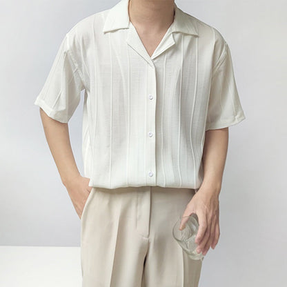Camicia bianca a righe verticali, maniche corte, indossata da uomo con pantaloni beige. Moda estiva elegante, stile casual chic.